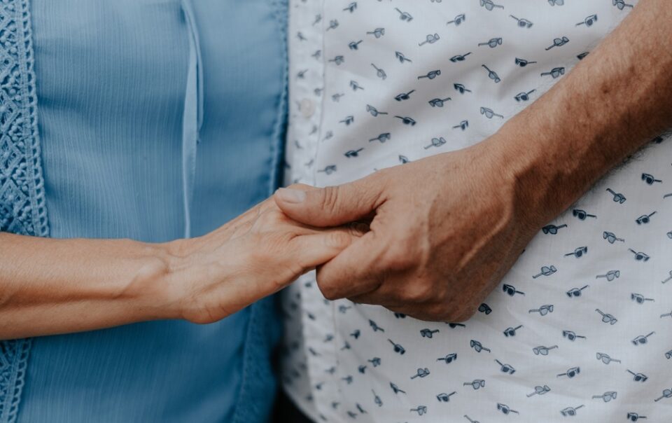 holding hands in hospital garb