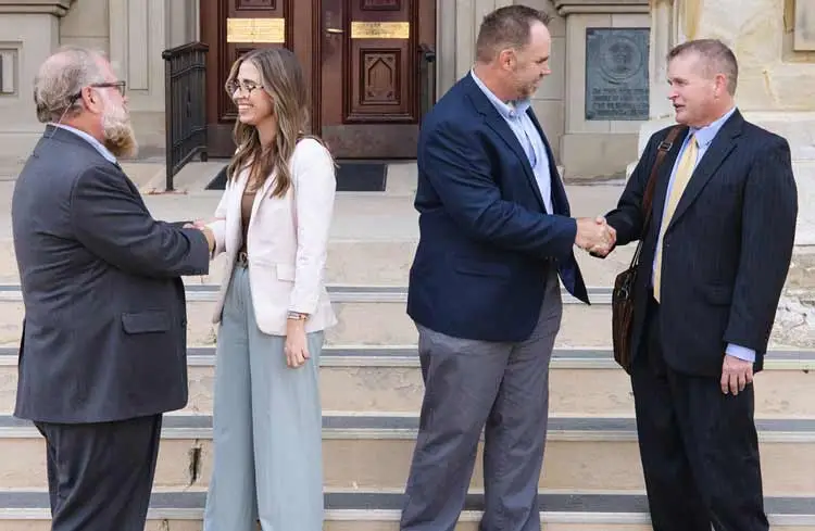 Mike Warren and Aaron McHenry handshake with clients